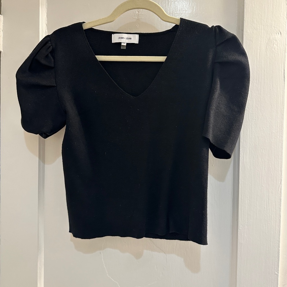Woman’s black blouse. Puffy shoulders.